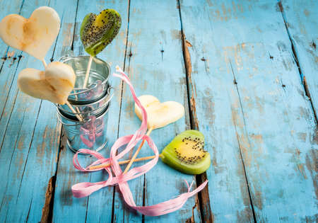 Idea for the congratulations Valentine: a bouquet of fruit (kiwi, apple, pear), carved in the form of hearts with gift ribbon and wrapping paperの写真素材