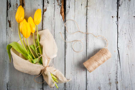 Bouquet of spring flowers tulips, on a white rustic table, top view, copy spaceの写真素材