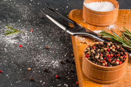 Stone kitchen table, prepared for cooking beef steak: with spices, salt and meat fork. Close view, copy spaceの写真素材