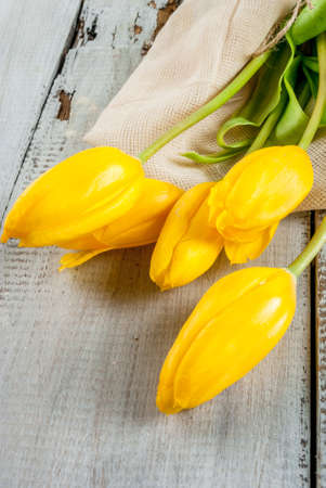 Bouquet of spring flowers tulips, on a white rustic table, close view, copy spaceの写真素材