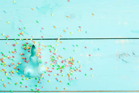 Easter background with cookie cutter in shape of symbol of Easter - Bunny and sugar sprinkles for cookies and cakes, top view, copy spaceの写真素材