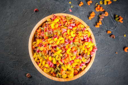 Colorful pasta kavatappi in wooden bowl, top view, copy spaceの写真素材