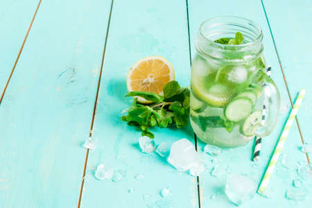 Refreshing summer drink - detox cocktail of mint, cucumber and lemon. On a light blue wooden table, bright sunlight, copy spaceの写真素材