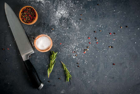 Grey stone kitchen table with spices, salt, herbs, spices and knife.の写真素材