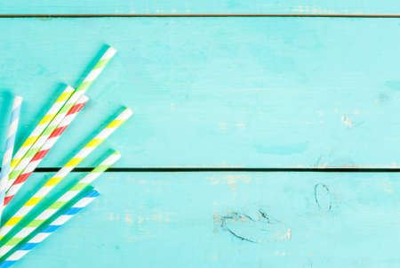 Summer blue wooden table with straws. Preparing for the party, vacation, top view, copy space