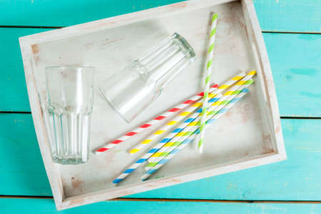 Summer blue wooden table, with glasses, a tray for drinks and straws. Preparing for the party, vacation, top view,の写真素材
