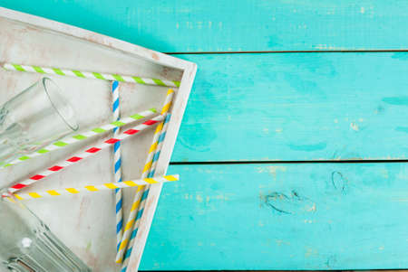 Summer blue wooden table, with glasses, a tray for drinks and straws. Preparing for the party, vacation, top view, copy spaceの写真素材