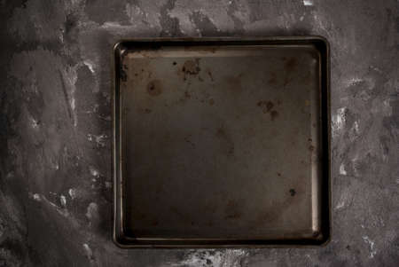Grey black spotted stone concrete table with a metal baking tray, background, blankの写真素材
