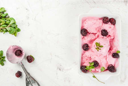 Homemade berry ice cream to the pan (bowl), with blackberries and mint leaves. On the white stone table, top view copy spaceの写真素材