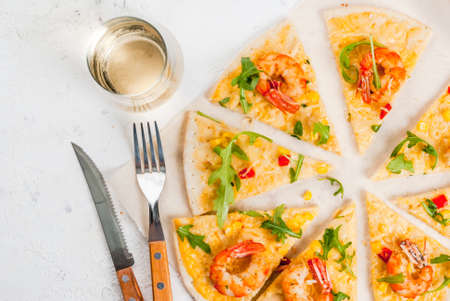 Dietary light vegetarian pizza with vegetables and shrimps prawns, with a glass of white wine on a white stone table copy space top viewの写真素材