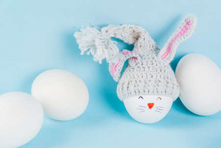 Ideas for holiday decoration. Easter. Egg in a knitted cap with ears, looking like a rabbit. With a...