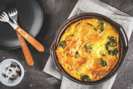 Traditional French food. quiche lorraine. Frittata. Baked in the oven egg omelet with vegetables - broccoli - cheese and greens. Rustic, homemade meal. On a gray concrete tableの写真素材
