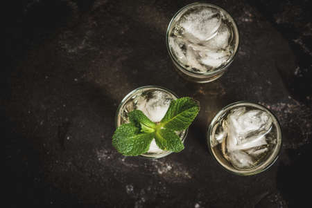 Alcohol cocktail made from golden tequila with ice cubes and mint. On a black concrete table. Copy space top viewの写真素材