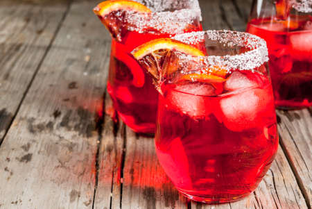 Refreshing summer drinks. Cocktail bloody orange margarita, in glasses on a wooden rustic table with a garnish of orange. Copy spaceの写真素材