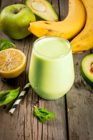 Healthy food. Dietary breakfast or snack. Green smoothies from yoghurt, avocado, banana, apple, spinach and lemon. On a rustic wooden table, with ingredients. Copy spaceの写真素材