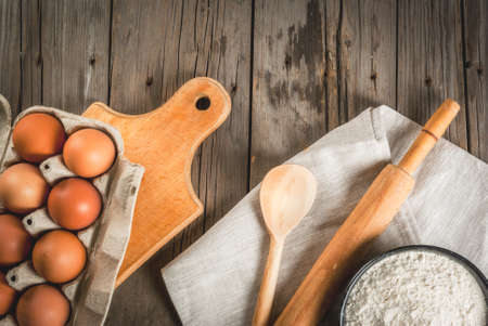 Baking background. Tools and ingredients for baking on the old rustic wooden table. Top view copy...