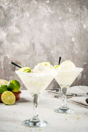 Refreshing summer alcoholic cocktail floating margarita. With tonic and salted lime ice cream with zest. With a lime garnish. On a white concrete table. Copy spaceの写真素材