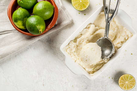 Homemade lemon ice cream. Refreshing lime sorbet in a bowl with a spoon for ice cream.  On a white concrete table.の写真素材