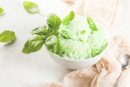 Summer desserts. Vegan food. Basil ice cream in a bowl on a white stone table.の写真素材