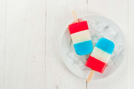 ICe cream. Patriotic Red White Blue Popsicles for 4th of July holiday, on white wooden table. copy space top viewの写真素材