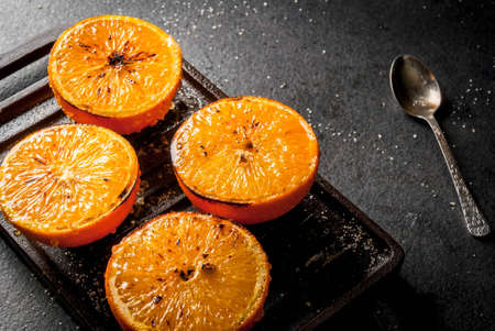 Ideas for a healthy dietary vegan breakfast. Paleo diet. Grilled oranges grapefruits. In the grill pan on a black stone table. Copy spaceの写真素材