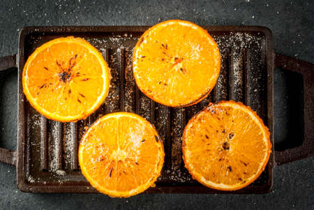 Ideas for a healthy dietary vegan breakfast. Paleo diet. Grilled oranges grapefruits. In the grill pan on a black stone table. Copy space top viewの写真素材
