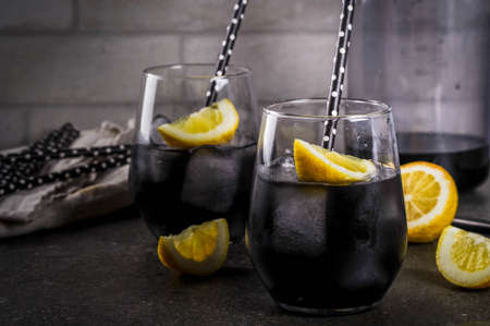 Trendy food. Summer refreshment drinks. Detox and diet concept. Black lemonade with charcoal, ice,...