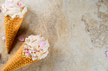 Summer refreshing desserts. Vegan diet food. Ice cream with rose petals and slices of almond, in...