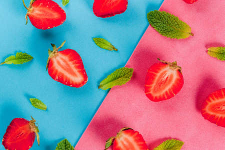 Fresh raw organic seasonal fruits and berries. The seamless pattern - mint, strawberry on a colorful blue and pink background. Top view copy spaceの写真素材