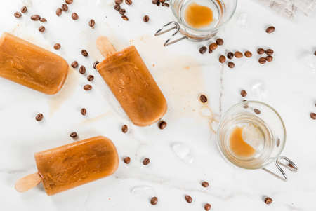 Summer desserts. Frozen drinks. Sweet popsicles made from coffee and milk. In coffee cups, On a...