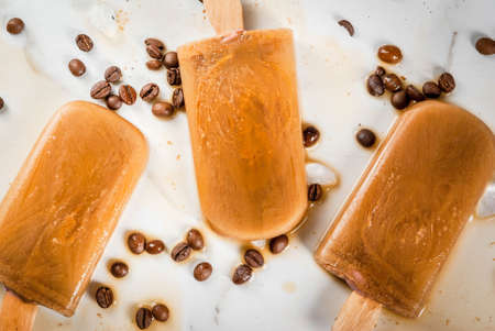 Summer desserts. Frozen drinks. Sweet popsicles made from coffee and milk. In coffee cups, On a...