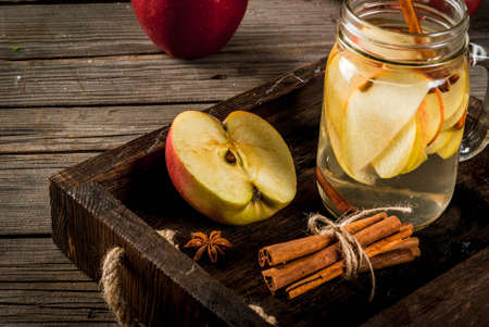 Fall and winter drinks. Autumn detox water with apple, cinnamon and pear in mason jar. On a rustic old wood background, with ingredients. Copy spaceの写真素材