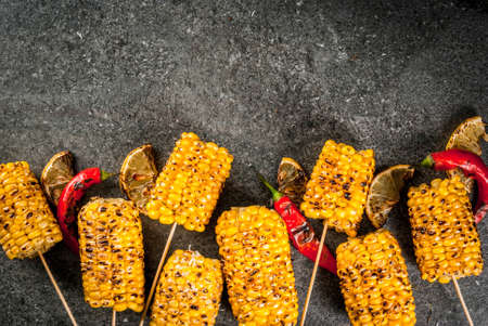 Summer food. Ideas for barbecue and grill parties. Grilled corn grilled on fire. With a sprinkle of...