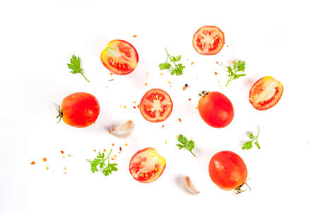 Food preparation background. Isolate. Spices and ingredients for cooking. Fresh tomatoes, whole and sliced, parsley, seasoning, spices, salt, garlic. Pattern top view copy spaceの写真素材