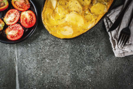 Mexican food. Traditional dish Tortilla de patatas - a casserole from potatoes and eggs, on a black stone table.の写真素材