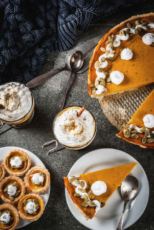 Traditional autumn dishes. Halloween, Thanksgiving. Pumpkin pie, pumpkin tartlets with whipped cream...