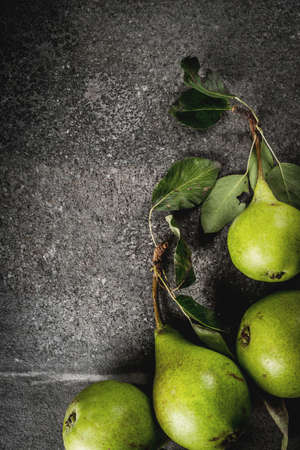 Fresh raw organic farm pear with leaves on a black stone table, copy space top viewの写真素材