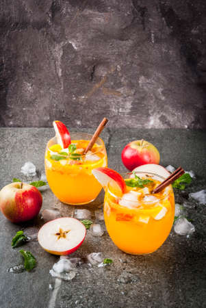 Traditional fall drinks, Apple cider mojito cocktails with mint, cinnamon and ice. On black stone table, copy spaceの写真素材