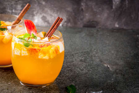 Traditional fall drinks, Apple cider mojito cocktails with mint, cinnamon and ice. On black stone table, copy spaceの写真素材