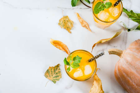 Fall and winter cold cocktails. Spicy pumpkin mojito with fresh mint, on white marble table. copy space top viewの写真素材