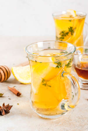 Fall and winter traditional drinks. Warming hot tea with lemon, ginger, spices (anise, cinnamon) and herbs (thyme), copy spaceの写真素材