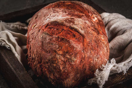 Trendy healthy food, superfood. Homemade beet bread with organic beetroot, in wooden try, on black stone table, copy spaceの写真素材