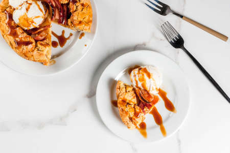 Traditional autumn baking, recipes for thanksgiving, Homemade wholegrain apple galette pie with organic apples and cinnamon, white marble table, copy space top viewの写真素材