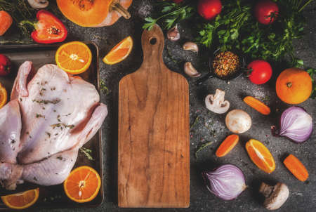 Cooking dinner for christmas, Thanksgiving. Traditional autumn ingredients are vegetables, pumpkin, mushrooms, chicken or turkey, fresh herbs, spices. On a dark table, Top view copy spaceの写真素材
