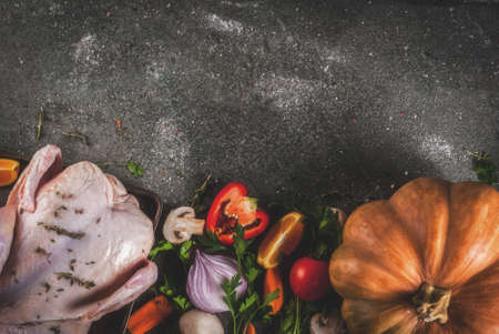 Cooking dinner for christmas, Thanksgiving. Traditional autumn ingredients are vegetables, pumpkin, mushrooms, chicken or turkey, fresh herbs, spices. On a dark table, Top view copy spaceの写真素材