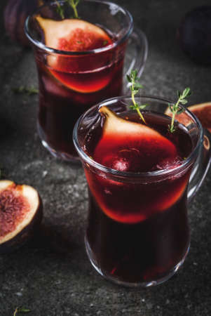 Fall and winter red sangria cocktail with thyme and figs, on black stone table, copy spaceの写真素材
