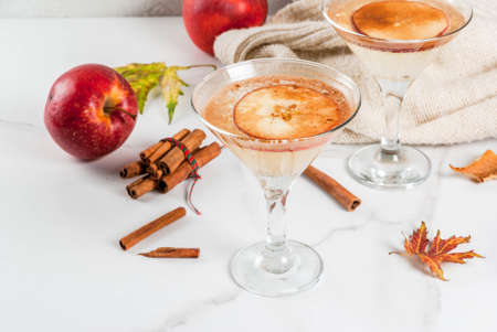 Fall and winter drinks, Apple cider martini margarita with cinnamon and apple garnish, on white marble table, copy spaceの写真素材
