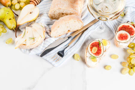 Sandwiches with ricotta or cream cheese, ciabatta, fresh figs, pears, grape, walnuts and honey on...