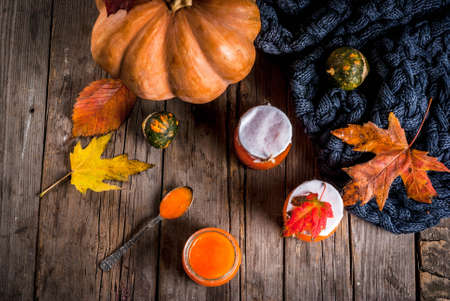 Autumn recipes, dishes from a pumpkin. Sweet spicy pumpkin jam in a serving jar, with a spoon, on an...