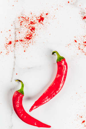 Raw fresh organic and dried ground chili pepper on white marble background top view copy space verticalの写真素材